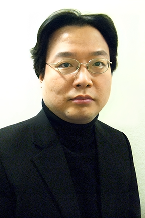 Headshot of asian person with short black hair and glasses wearing a black blazer over a black turtleneck