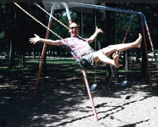 Action shot of of Larry Roark swinging on a swing set.