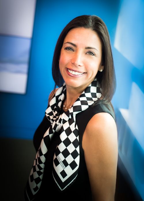 Elizabeth Nieto posing in front of blue background. 