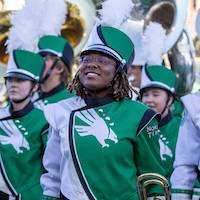 A trombone player smiles up at the audience after performing