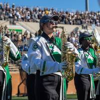 An alto saxophone player performs the pregame show on a sunny morning