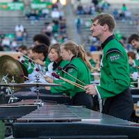 A profile view of several marimba players during the halftime show