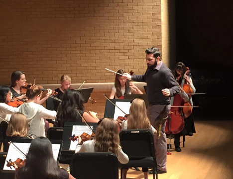 Director in front of group of musicians