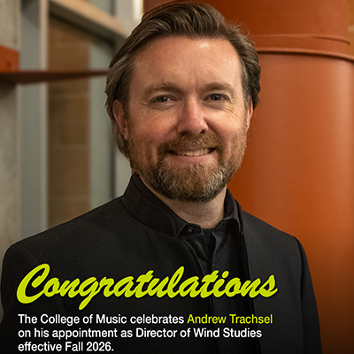 Dr. Trachsel is smiling while standing wearing all black clothing with an open collared shirt.