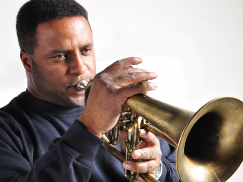 Frank Greene publicity shot, performing trumpet in front of white background